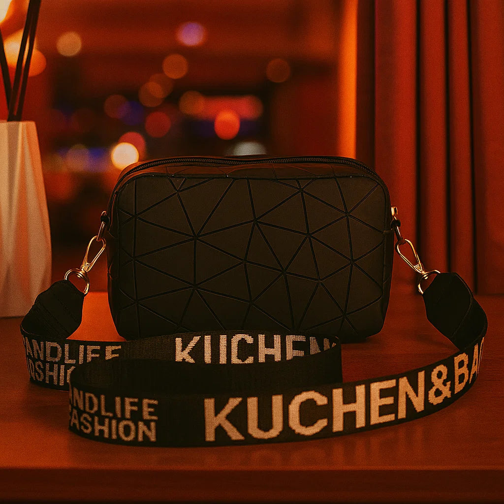 Black geometric-patterned bag with a branded strap on a wooden surface.